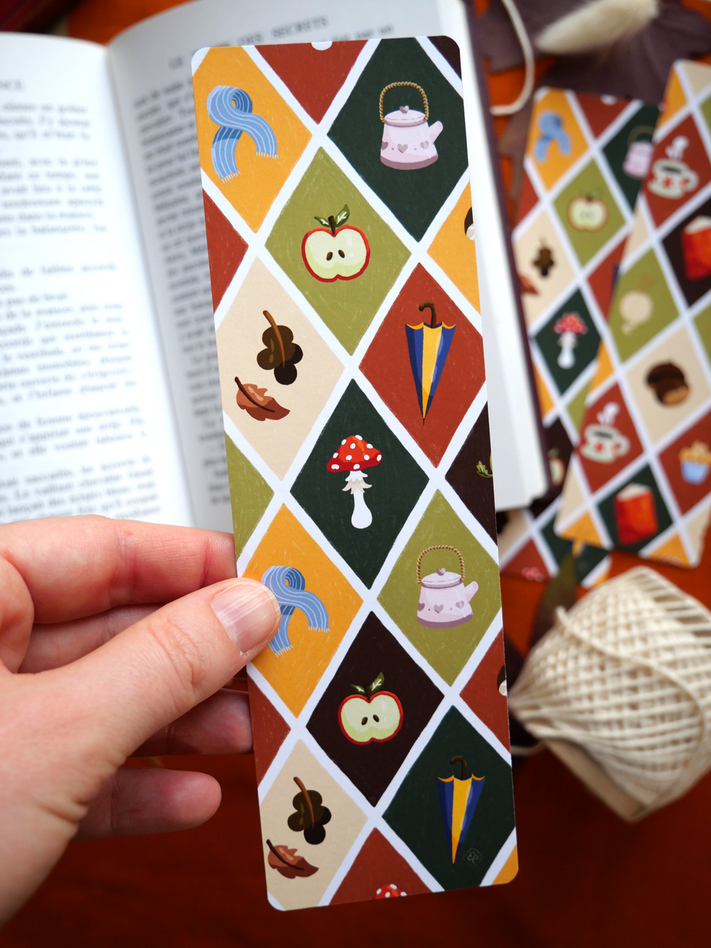 Marque-page "Patchwork d'automne" par chatdudesert. Photo du marque-page tenu dans la main, vue sur le recto.